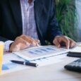 Yrittäjä tarkastelee talouskaaviota tabletilla työpöydän ääressä